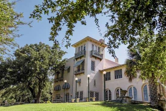 Fachada de Laguna Gloria vista desde los jardines con árboles en primer plano