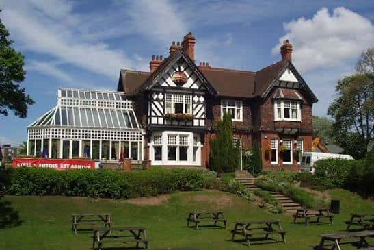 Exterior del Carlton Tavern con jardín y zona de picnic al aire libre bajo cielo despejado