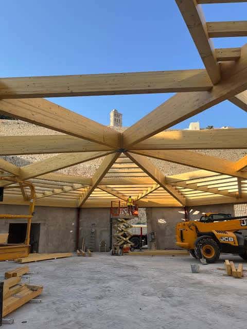 Interior en construcción de Sa Peixateria con estructura de madera y maquinaria