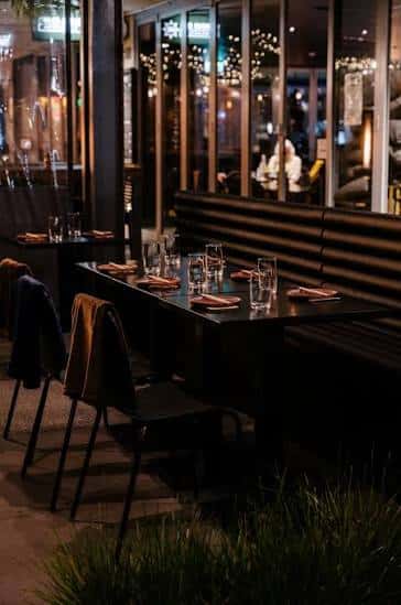 Terraza exterior del restaurante con mesas dispuestas para cena y decoración con luces