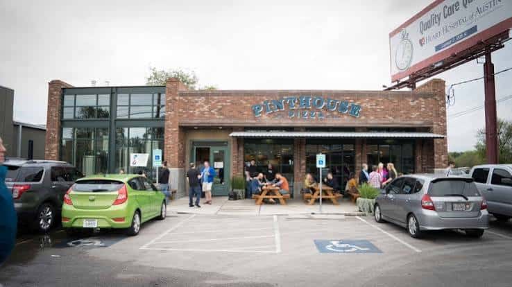 Vista exterior del local Pinthouse Pizza en Burnet Road con clientes en mesas al aire libre