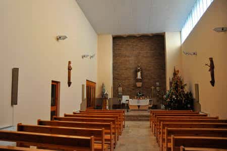 Interior de la iglesia del monasterio con bancos de madera y altar