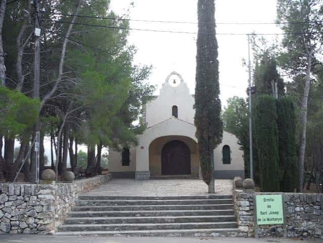 Acceso principal a la ermita con escaleras y señalización verde