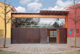 Entrada principal del edificio con estructura de madera y cristal, mostrando el acceso al servicio municipal
