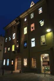 Fachada del Museu del Cinema iluminada por la noche con carteles de cine en las ventanas