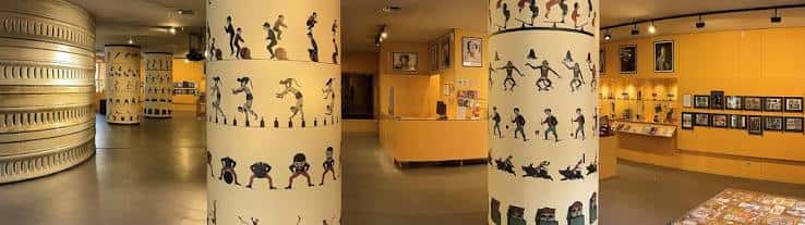 Interior del museo con columnas decoradas con siluetas de personajes de cine y exposiciones en las paredes