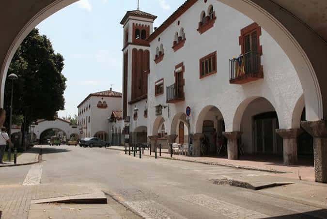 Vista de la Plaça de l'Assumpció con edificios blancos y arcos, ideal para eventos al aire libre