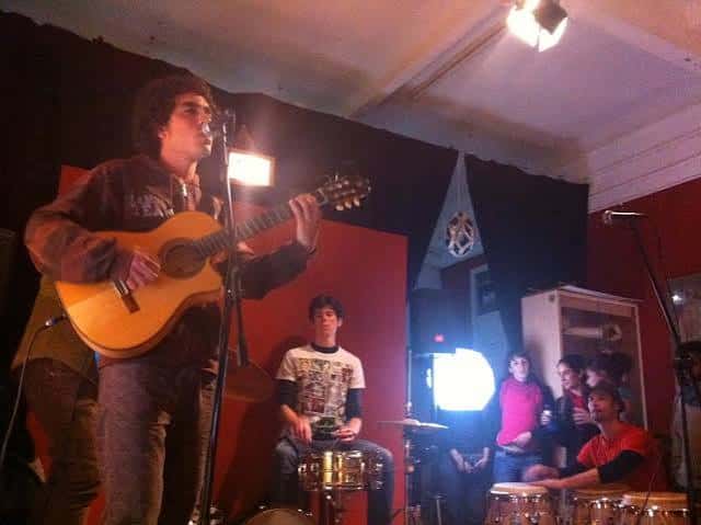 Concierto en vivo en El Taller Tumbao con músico tocando guitarra en el escenario