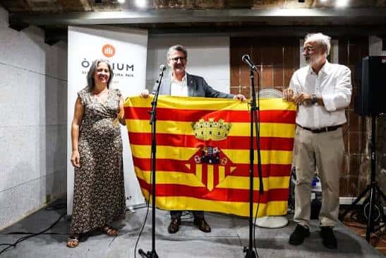 Presentación de una bandera en un acto de Òmnium Cultural