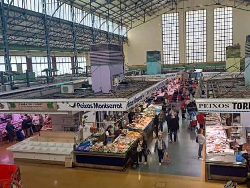 Interior del mercado mostrando los puestos de pescado y la estructura metálica del techo