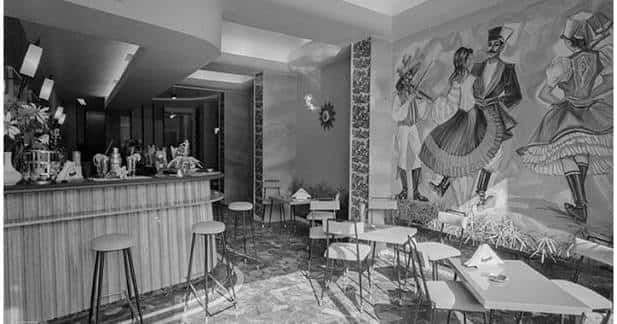 Interior del Café Bar Hungaria con barra, mesas y mural tradicional en blanco y negro