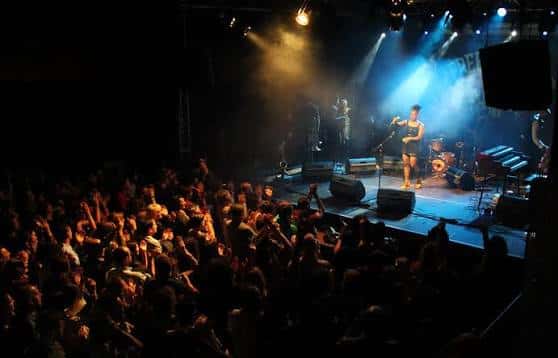 Concierto en vivo en el escenario de Espacio Vías con público y efectos de luz