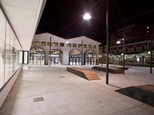 Interior del patio de Espacio Vías por la noche con rampas y arquitectura moderna