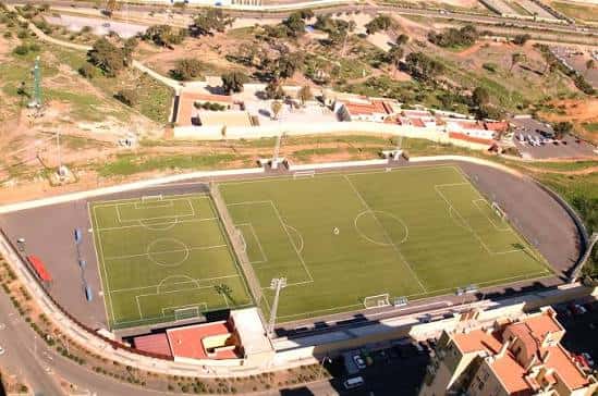 Vista aérea de las dos canchas deportivas con pistas de atletismo y zonas residenciales alrededor