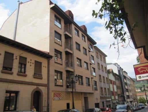 Calle típica del barrio de Pando con edificios de viviendas y comercios locales