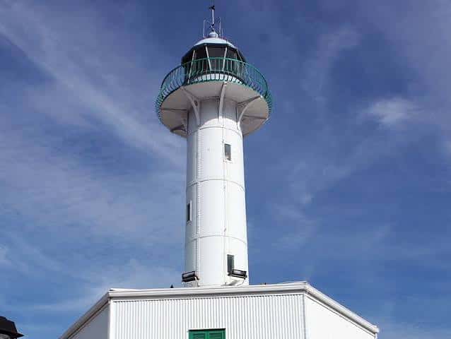 Primer plano de la linterna y cúpula del Faro de la Banya contra el cielo azul