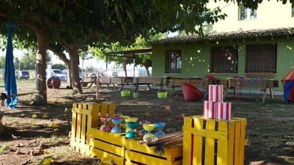 Zona de actividades infantiles con juegos y decoración colorida en el patio