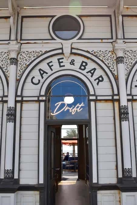 Entrada principal del Drift Bar & Kitchen con letrero de neón y arquitectura victoriana