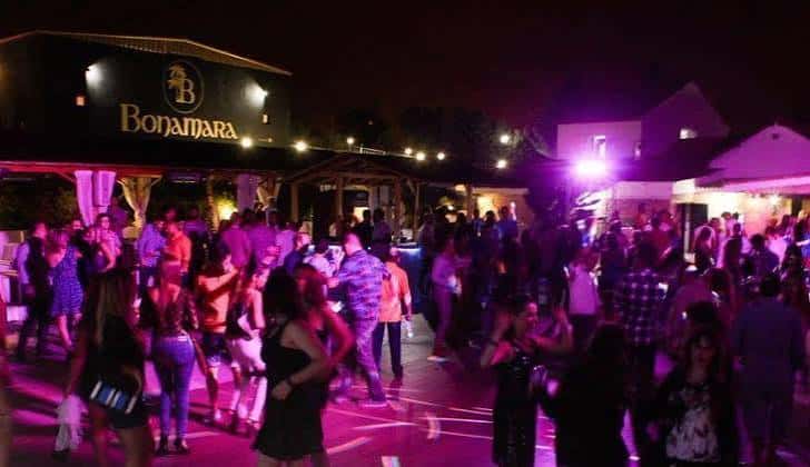 Vista nocturna de la discoteca Bonamara con gente bailando y luces de neón