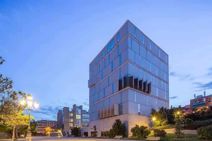 Fachada moderna de la biblioteca al atardecer con iluminación ambiental