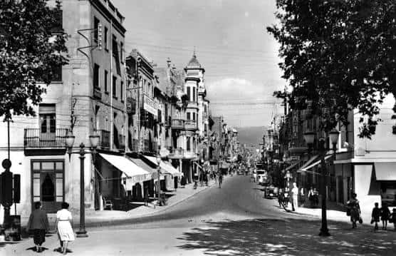 Vista histórica del Carrer d'Anselm Clavé con edificios tradicionales y peatones
