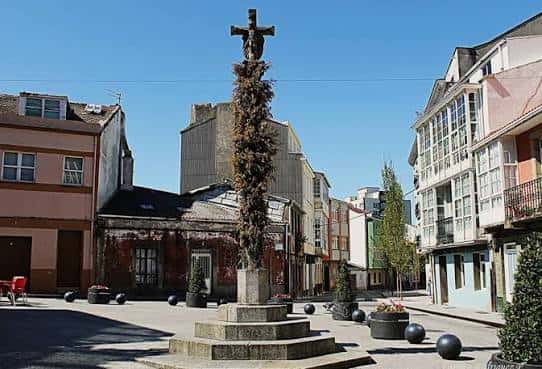 Vista panorámica de la plaza con el crucero central y edificios históricos alrededor