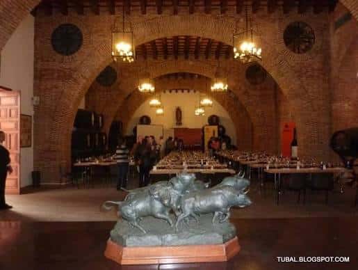 Sala de eventos con arcos de ladrillo y mesa de cata preparada