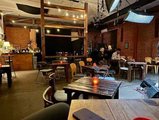 Interior del Monks Jazz Club con mesas, barra y ambiente acogedor