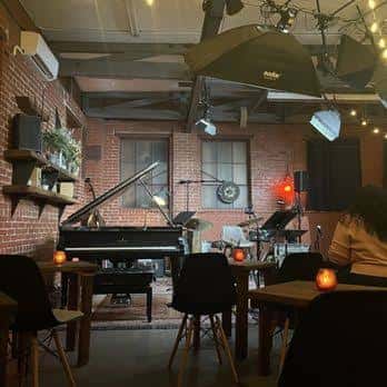 Escenario con piano de cola y equipo de sonido en el Monks Jazz Club