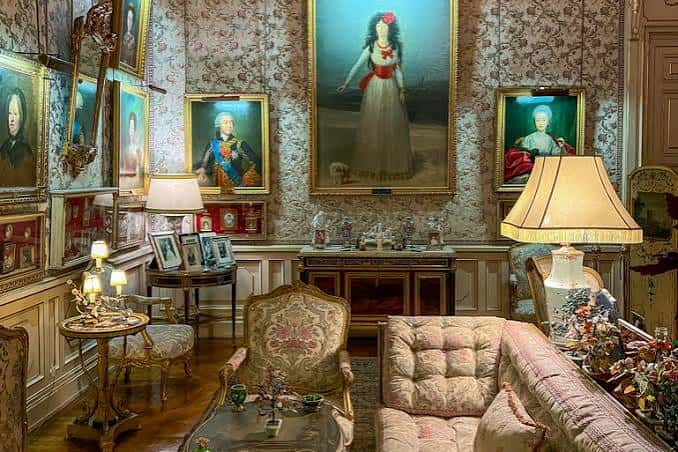 Sala de exposiciones con retratos históricos y mobiliario clásico
