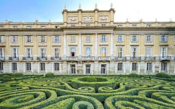 Fachada del palacio con jardín de setos geométricos al frente