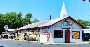 Vista exterior del Little Longhorn Saloon con su distintiva fachada blanca y techo inclinado