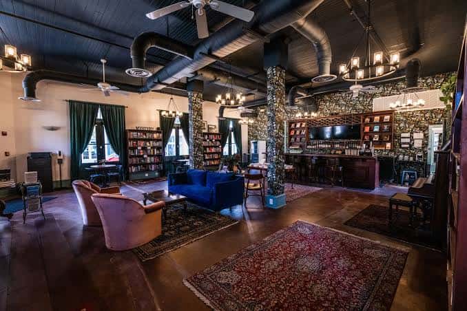 Interior del Vintage Bookstore & Wine Bar con estanterías de libros, barra de vino y zona de estar con sofás