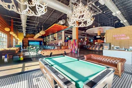 Sala de juegos con mesa de billar y sofás de cuero