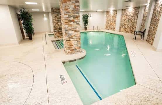 Piscina interior del hotel con paredes de piedra y zona de hidromasaje