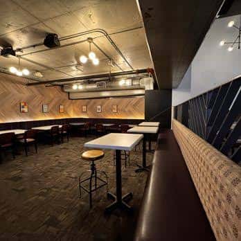 Sala de eventos con mesas altas y ambiente industrial