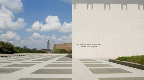Detalle de la pared exterior con inscripción del nombre del museo y plaza pavimentada