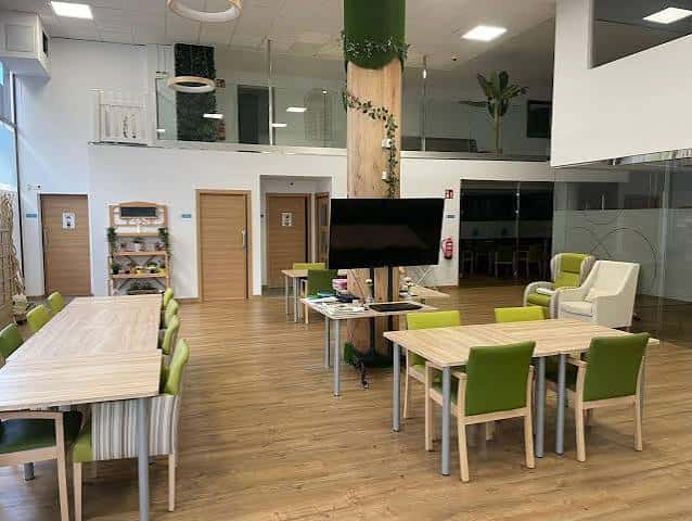 Sala de reuniones con mesas y sillas verdes