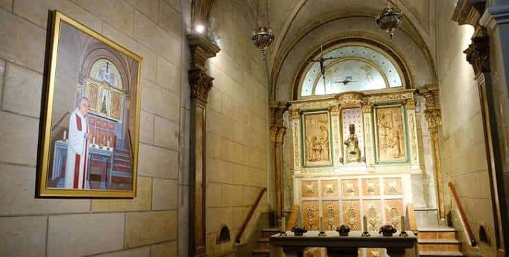 Interior de la iglesia con altar y pintura religiosa en la pared