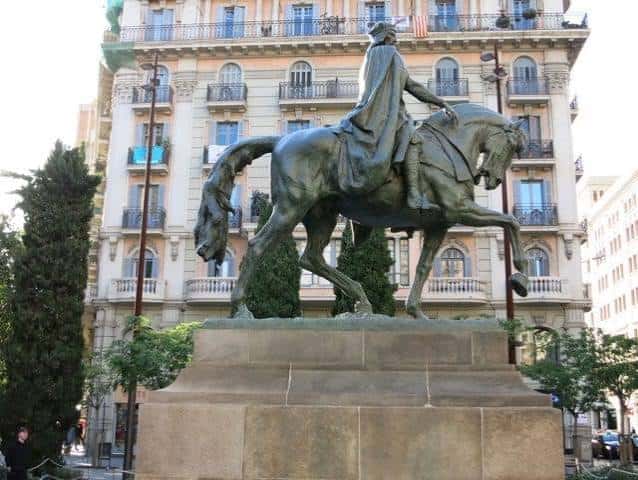 Primer plano de la estatua ecuestre de Ramon Berenguer III el Gran con edificios históricos de fondo