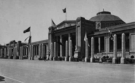 Fachada histórica del Palau de la Metal·lúrgia durante la Exposición Internacional de 1929, con columnas y banderas