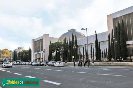 Vista panorámica del Palau de la Metal·lúrgia en el Parc de Montjuïc, con árboles y tráfico en primer plano