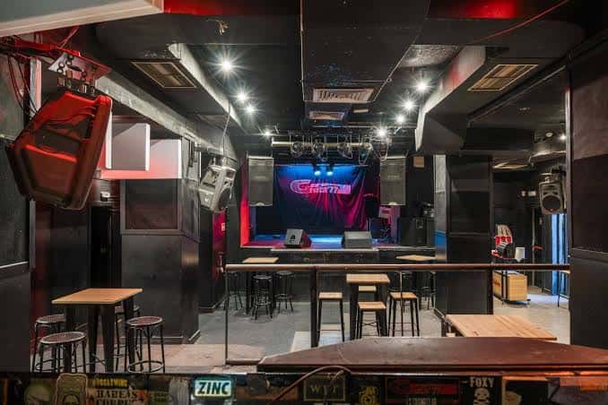 Interior de la sala de conciertos con mesas y escenario