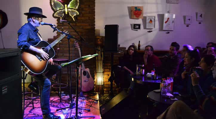 Concierto en vivo en El Volander con músico tocando guitarra frente a público