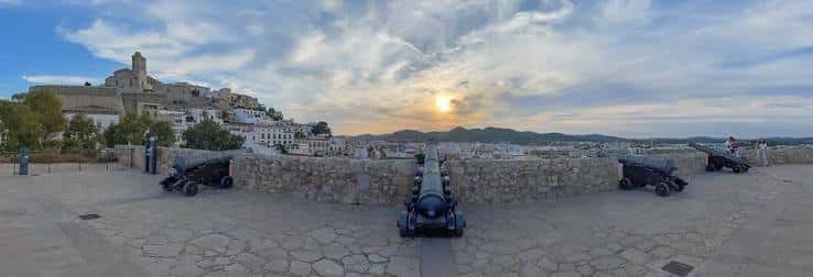 Vista panorámica del Baluarte de Santa Lucía con cañones históricos y atardecer sobre Dalt Vila