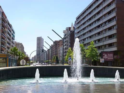 Vista diurna de la Gran Vía de Logroño con fuente central y edificios residenciales