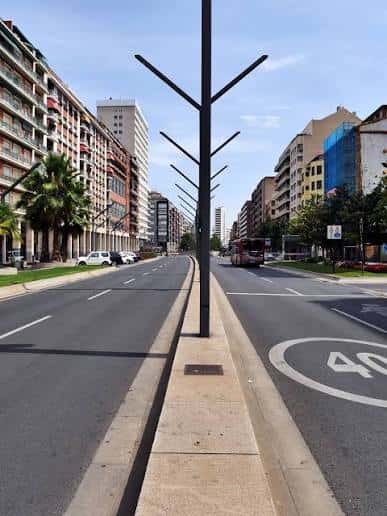Perspectiva de la Gran Vía con farolas modernas y tráfico ligero en día soleado