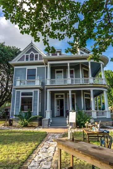 Vista exterior del The Wolf House en Austin con su porche victoriano y jardines