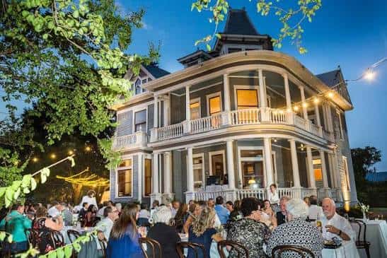 Evento en el patio del The Wolf House con iluminación nocturna y decoración festiva