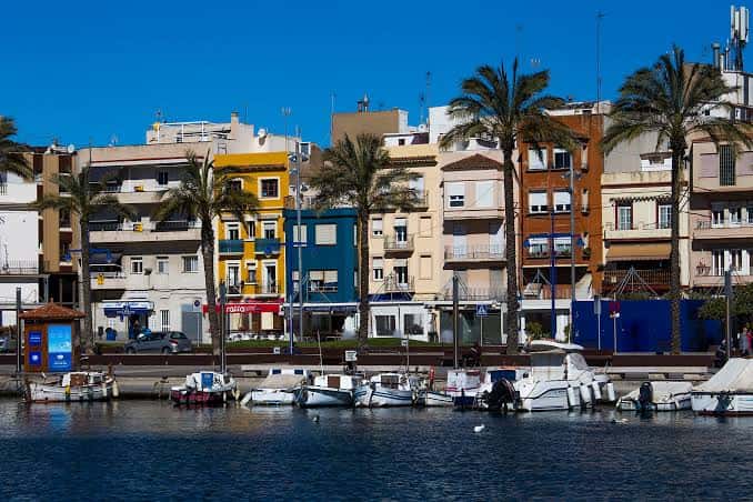 Puerto deportivo con embarcaciones y edificios coloridos al fondo